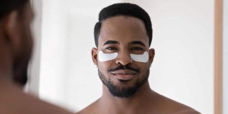 Man wearing specific gel pads to reduce eye bags.