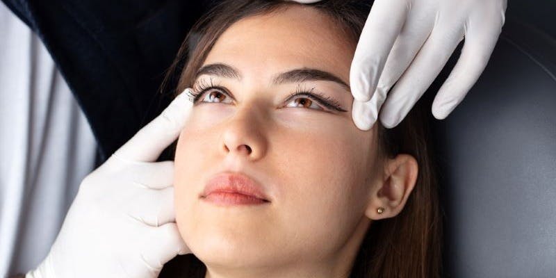 Woman undergoing eye lid surgery during consultation with a surgeon