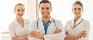 Three intimate area plastic surgery doctors standing and smiling.