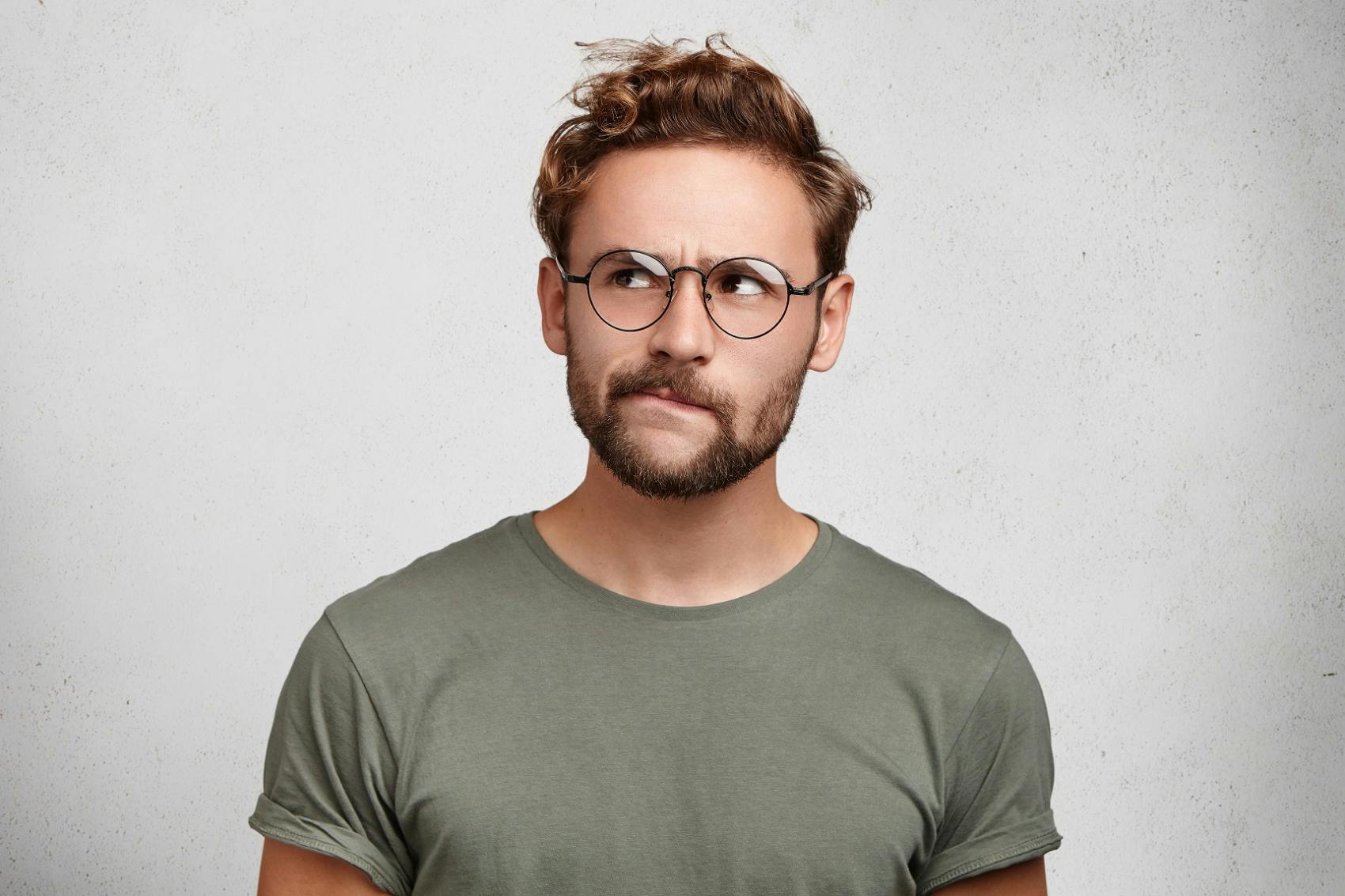 Man in glasses thinking about his hair transplant aftercare