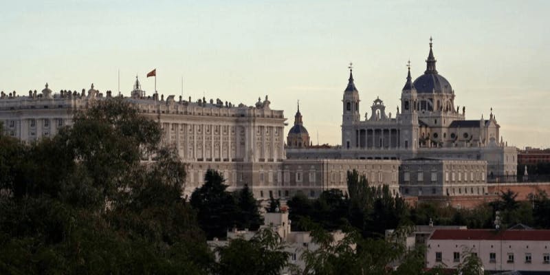 Eine spanische Flagge weht über einem Palast in Madrid, der Hauptstadt eines der besten Länder für IVF.