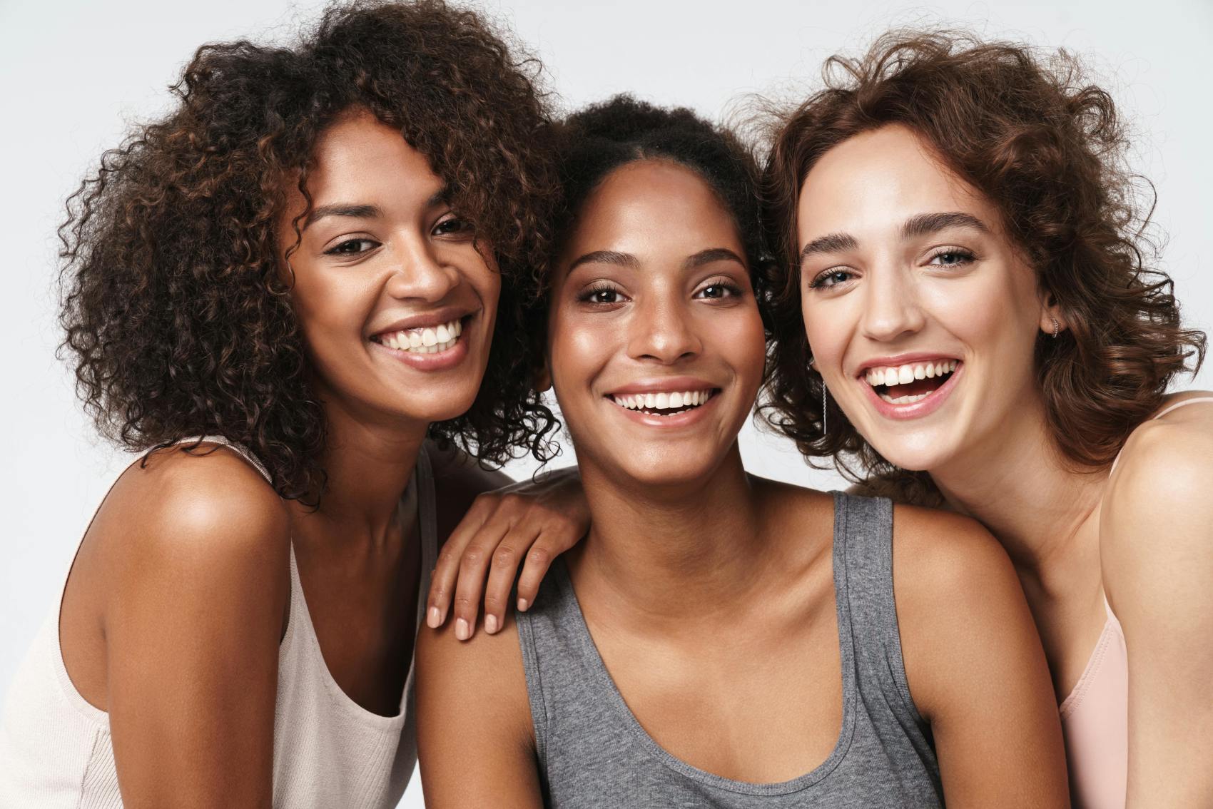 Three women smiling together and hugging